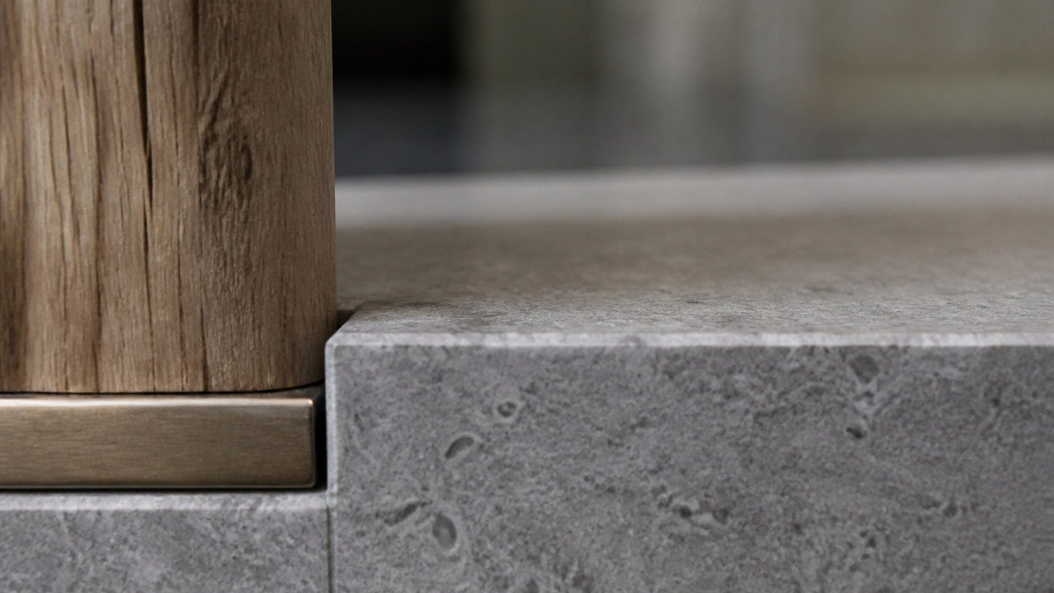 Close study of honed stone meeting timber or metal in a workplace