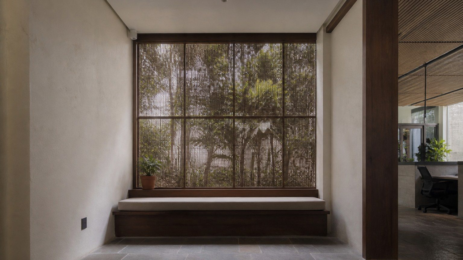 Quiet waiting alcove in a workplace with a low seat and screened daylight