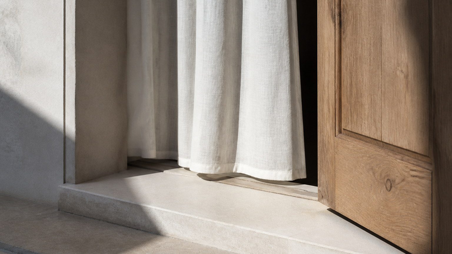 Quiet residential detail of a stone window sill, timber door and linen in daylight