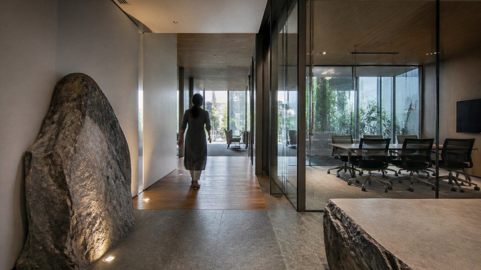 Wide office interior where stone is used as a pause in circulation