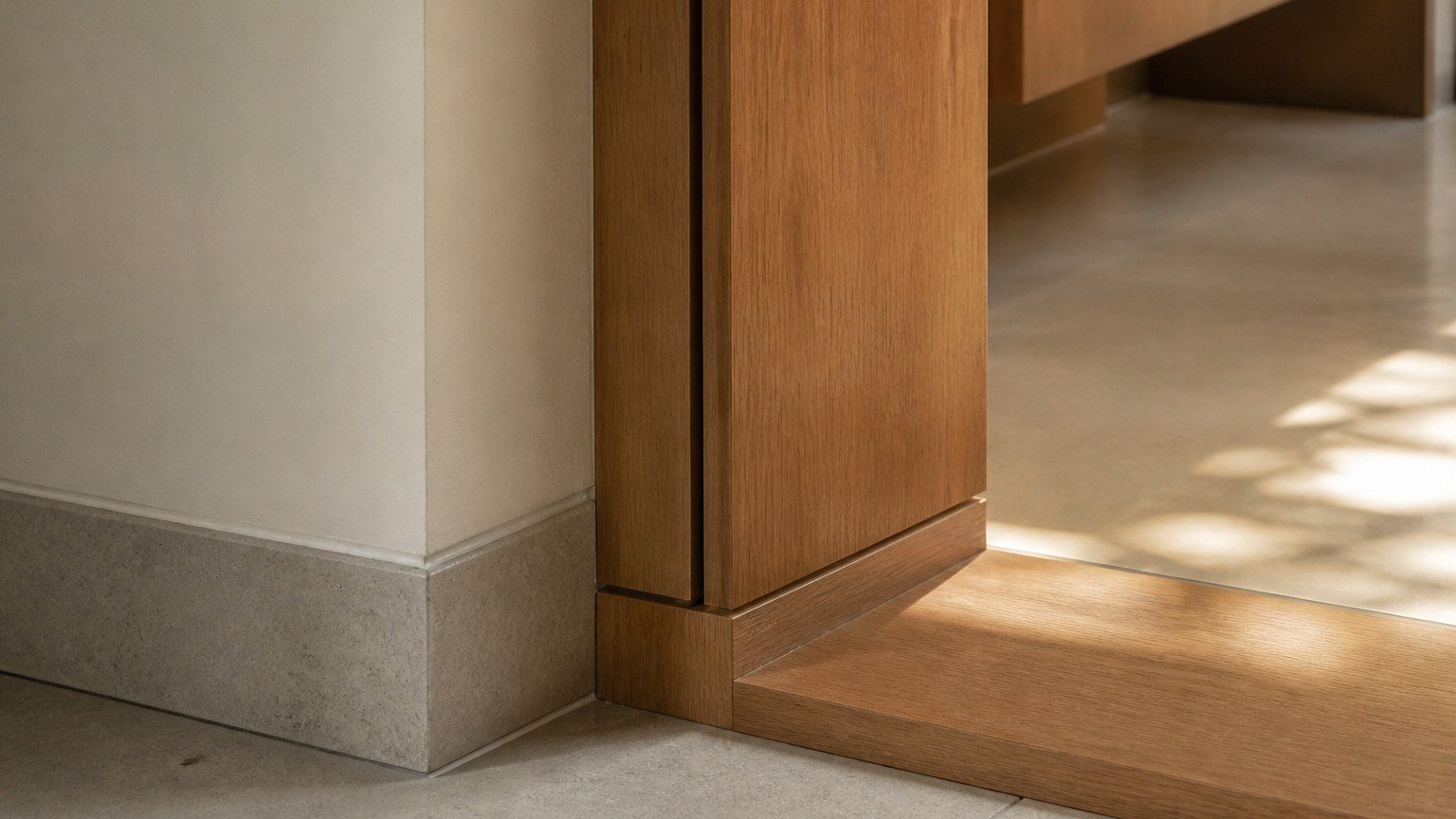 Timber millwork meeting plaster and stone at a clean interior junction