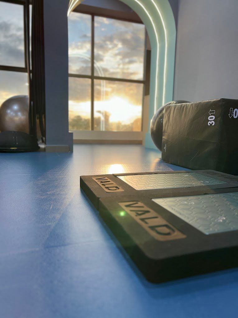 Illuminated arch with sunset beyond, plates and plyo box on the blue floor