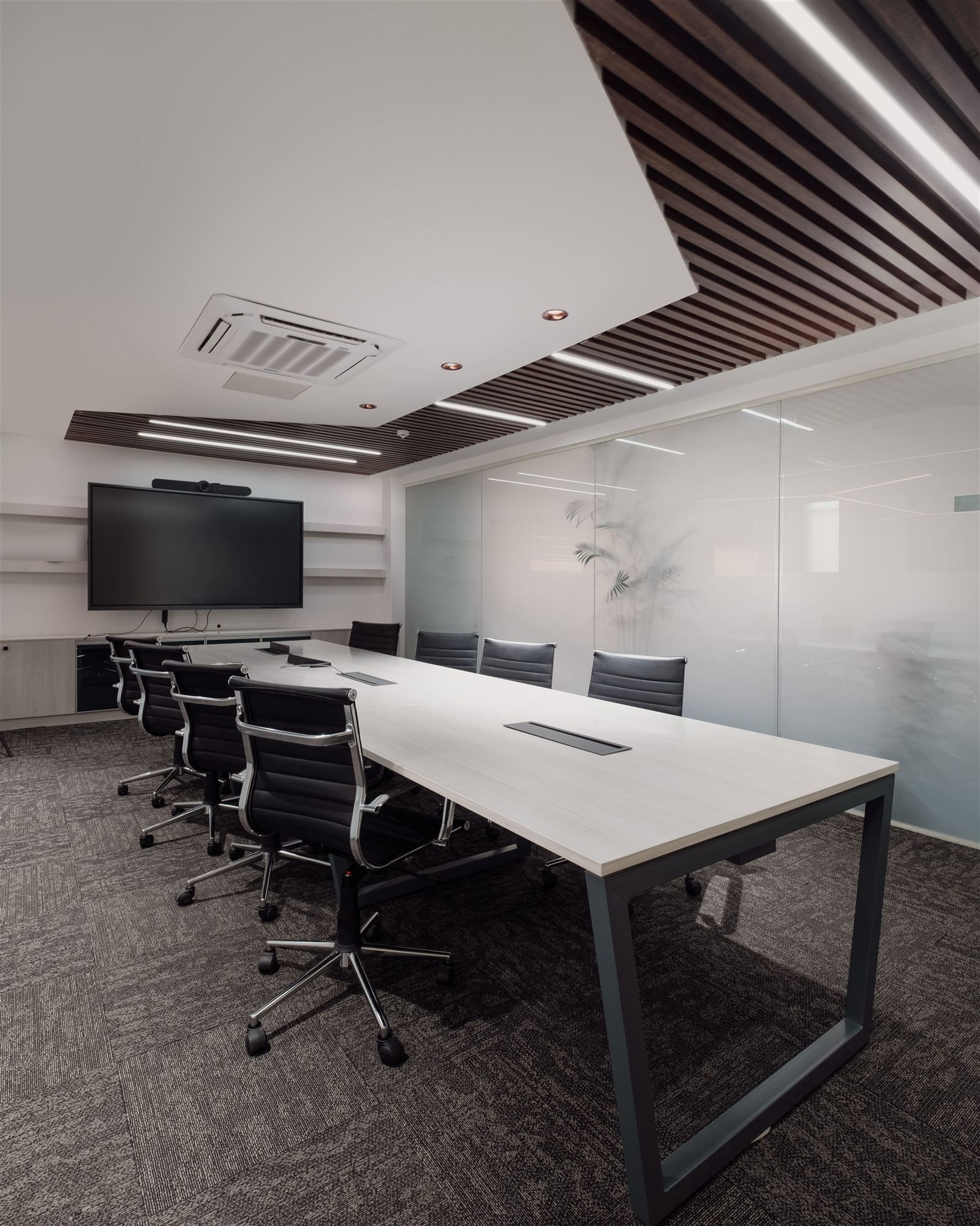 Boardroom with long conference table and frosted glass wall