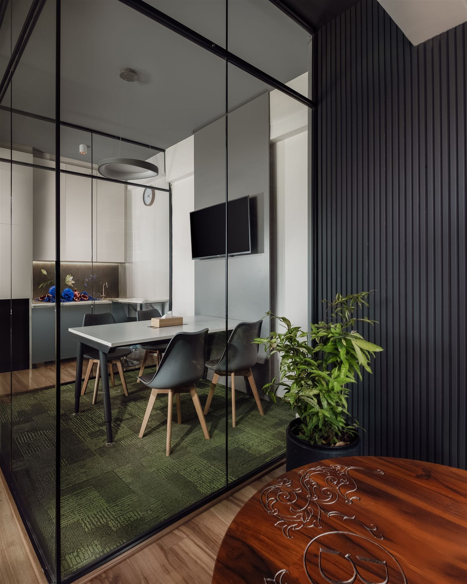 Glass-walled meeting room reflecting the pantry beyond
