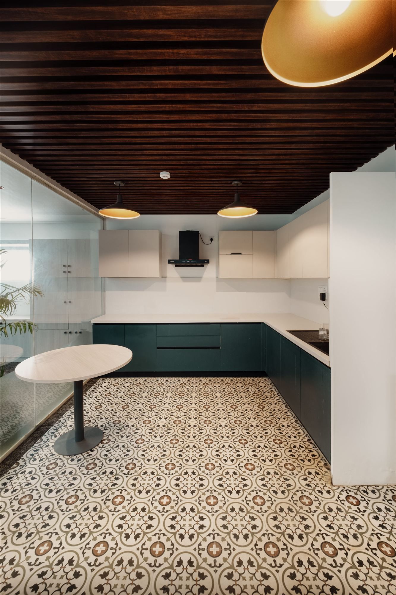 Pantry with dark green cabinetry and patterned tile floor