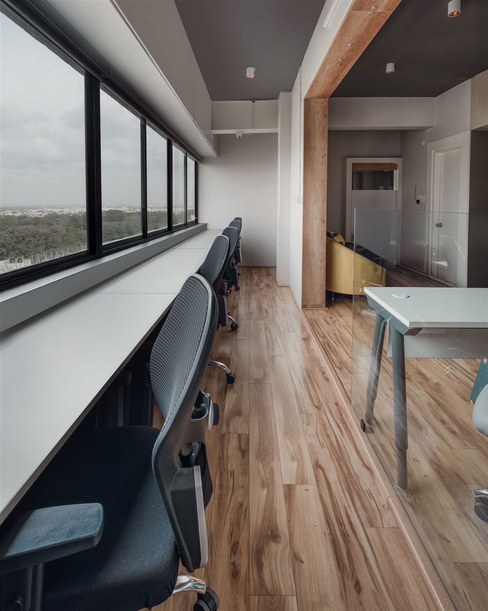 Window-side desks along a wood-accented corridor